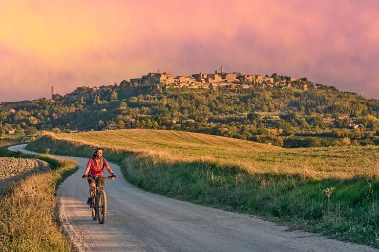 Una donna in bici sulle colline toscane